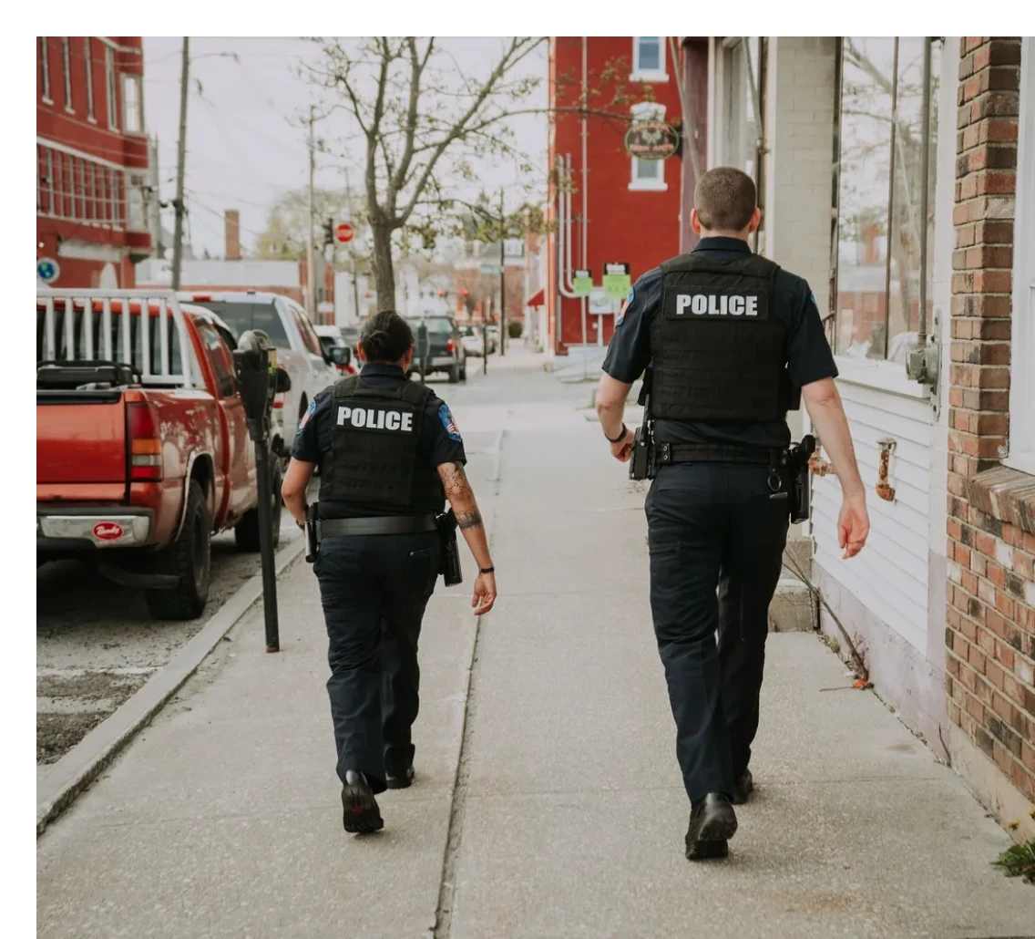 Police officers walking down a city sidewalk.